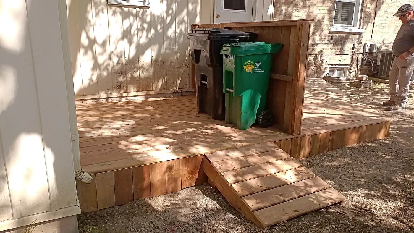 Low wooden deck with a sloped access ramp running down to the ground